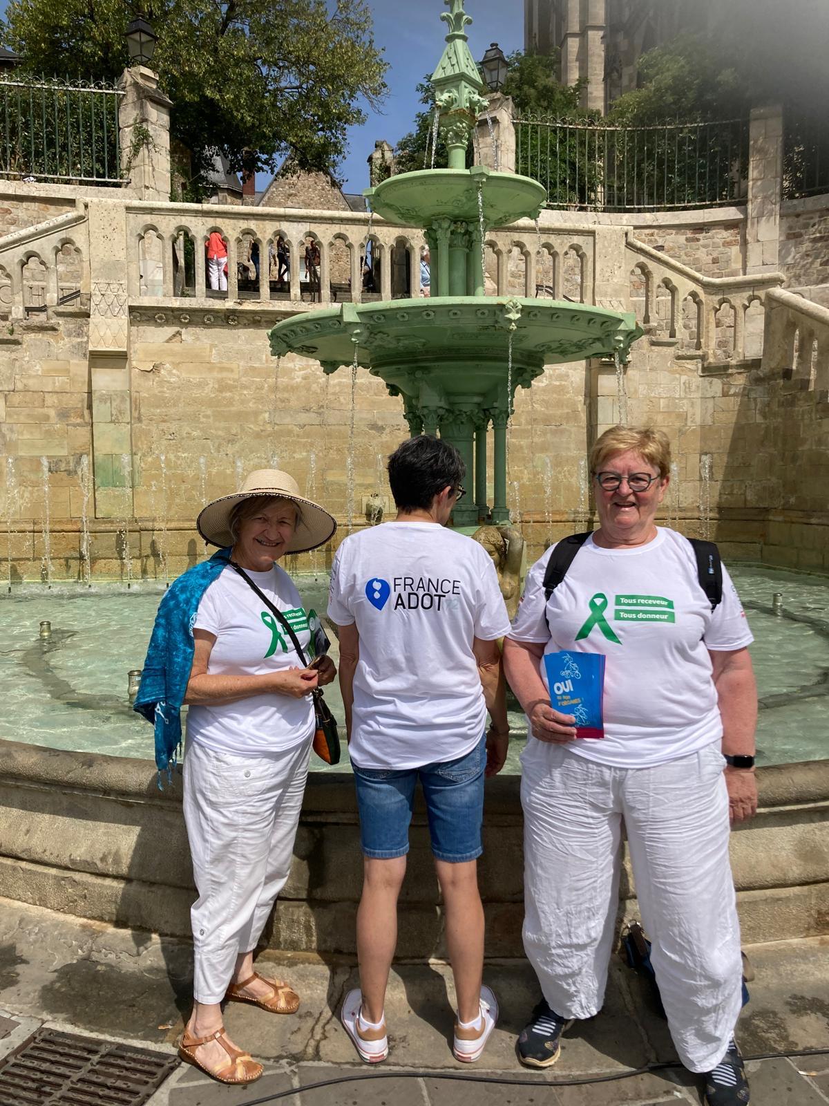 Des bénévoles devant la fontaine de la place des Jacobins. Elles montrent leur tee shirt "Tous donneurs, tous receveurs".