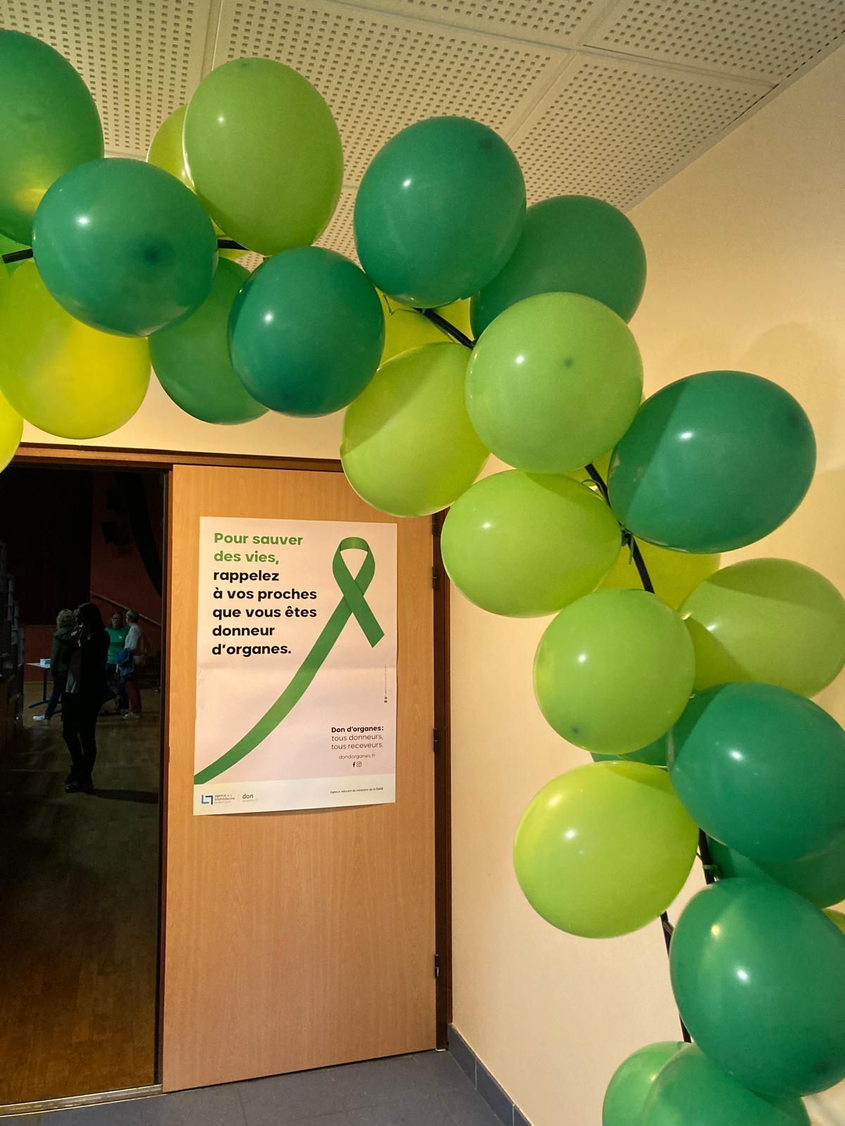 Des ballons avec deux teintes de vert décorent la salle