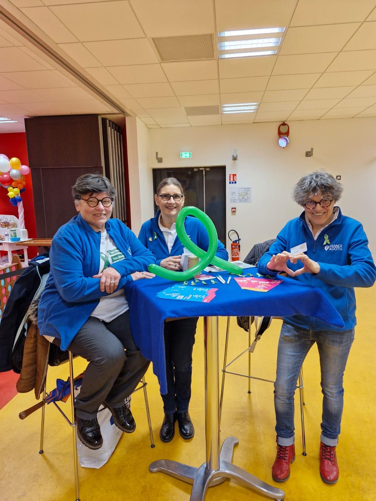 3 bénévoles, Thérèse, Louise et Sylvie autour d'un noeud vert qui symbolise le don d'organes